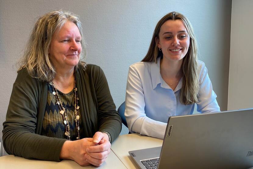 Marion Koopman en Demi Lamers aan het werk achter een laptop