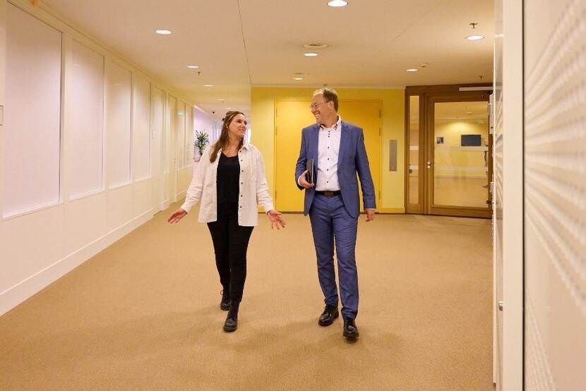 Elisa en Jacco wandelen in een gang