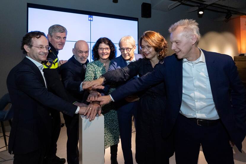 Directeuren uit de werkgroep Algoritmeregisters drukken gezamenlijk op een knop
