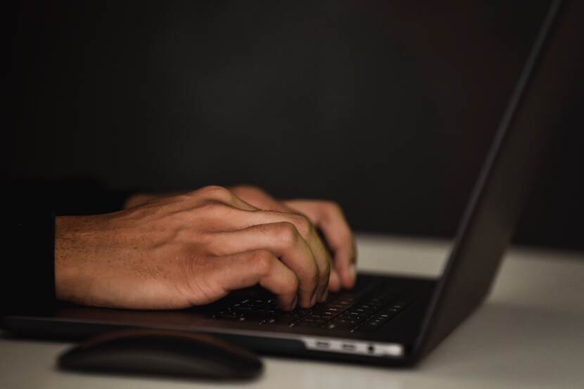 Handen op toetsenbord van laptop